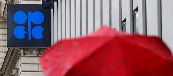 A person carrying an umbrella walks by the OPEC headquarters in Vienna - Sputnik Afrique