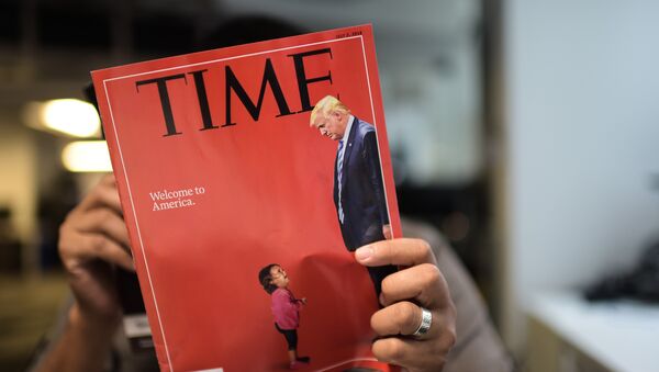 An AFP journalists reads a copy of Time Magazine with a front cover using a combination of pictures showing a crying child taken at the US Border Mexico and a picture of US President Donald Trump looking down, on June 22, 2018 in Washington DC. - Sputnik Afrique