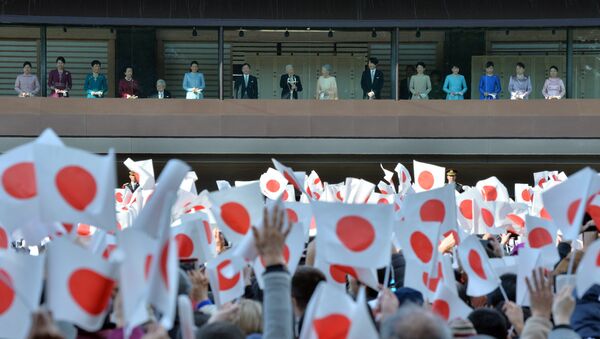 Japanese Emperor Akihito (C) and Empress Michiko (7th R) greet well-wishers with other members of the royal family from the balcony of the Imperial Palace in Tokyo on January 2, 2016 - Sputnik Afrique