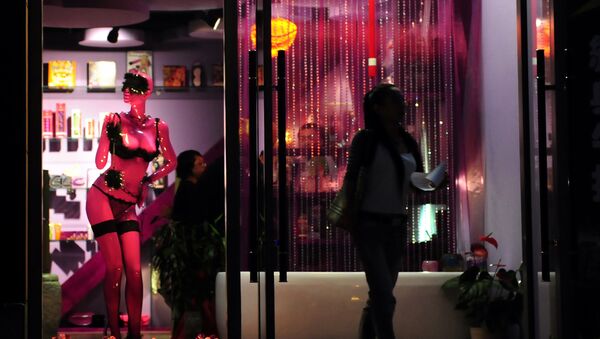 A woman steps out of the Boutique De L'Amour sex shop in Beijing on June 13, 2009. - Sputnik Afrique