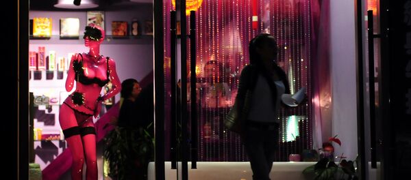 A woman steps out of the Boutique De L'Amour sex shop in Beijing on June 13, 2009. - Sputnik Afrique