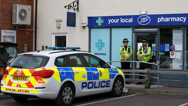 Police officers guard outside a branch of Boots pharmacy, which has been cordoned off after two people were hospitalised and police declared a 'major incident', in Amesbury, Wiltshire, Britain, July 4, 2018 - Sputnik Afrique