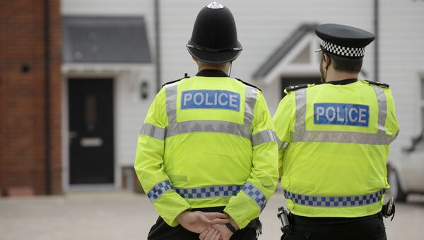 British police officers stand facing a residential property in Amesbury, England, Wednesday, July 4, 2018. - Sputnik Afrique