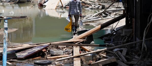 A local resident walks in a flooded area in Mabi town in Kurashiki A local resident walks in a flooded area in Mabi town in Kurashiki - Sputnik Afrique