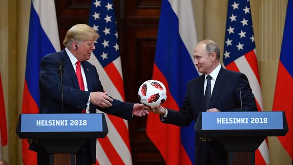 Russia's President Vladimir Putin (R) offers a ball of the 2018 football World Cup to US President Donald Trump during a joint press conference after a meeting at the Presidential Palace in Helsinki, on July 16, 2018 - Sputnik Afrique