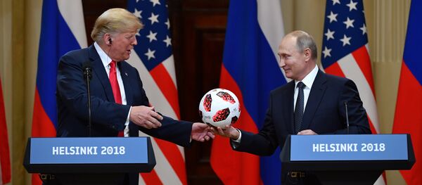 Russia's President Vladimir Putin (R) offers a ball of the 2018 football World Cup to US President Donald Trump during a joint press conference after a meeting at the Presidential Palace in Helsinki, on July 16, 2018 - Sputnik Afrique