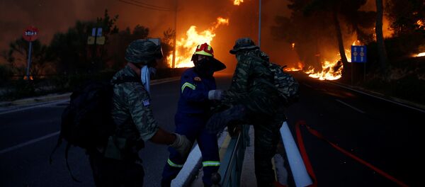 Firefighters and soldiers fall back as a wildfire burns in the town of Rafina, near Athens, Greece, July 23, 2018 - Sputnik Afrique