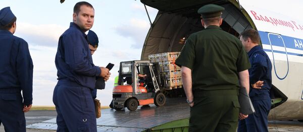 Russian military service personnel watch as supplies are loaded onto an Antonov An-124 Ruslan - Widebody at the former Chateauroux-Deols Marcel Dassault Airport in central France on July 20, 2018. - Sputnik Afrique