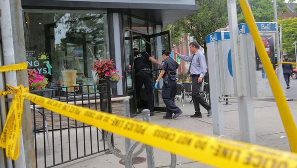 Police officers enter a coffee shop damaged by gunfire while investigating a mass shooting on Danforth Avenue in Toronto, Canada, July 23, 2018 - Sputnik Afrique