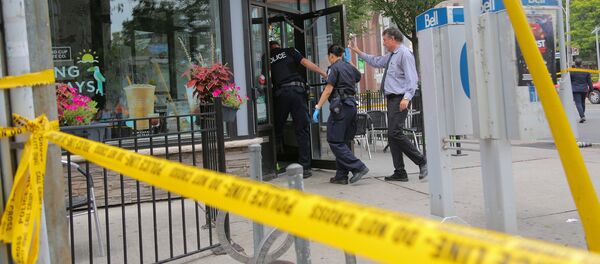 Police officers enter a coffee shop damaged by gunfire while investigating a mass shooting on Danforth Avenue in Toronto, Canada, July 23, 2018 - Sputnik Afrique