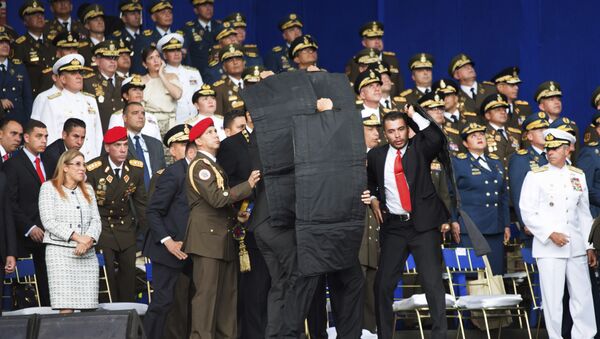 Personal de seguridad rodea al presidente de Venezuela, Nicolás Maduro, durante un incidente mientras daba un discurso en Caracas - Sputnik Afrique