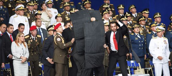 Personal de seguridad rodea al presidente de Venezuela, Nicolás Maduro, durante un incidente mientras daba un discurso en Caracas - Sputnik Afrique
