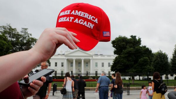 A tourist holds a Make America Great Again hat outside the White House in Washington, U.S., August 2, 2018. - Sputnik Afrique