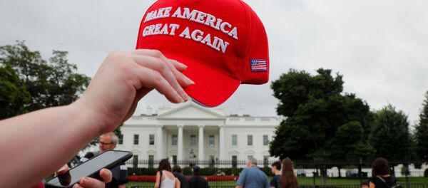 A tourist holds a Make America Great Again hat outside the White House in Washington, U.S., August 2, 2018. - Sputnik Afrique