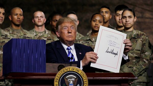 U.S. President Donald Trump holds up the National Defense Authorization Act after signing it in front of soldiers from the U.S. Army's 10th Mountain Division at Fort Drum, New York, U.S., August 13, 2018. REUTERS/Carlos Barria - Sputnik Afrique