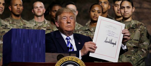 U.S. President Donald Trump holds up the National Defense Authorization Act after signing it in front of soldiers from the U.S. Army's 10th Mountain Division at Fort Drum, New York, U.S., August 13, 2018. REUTERS/Carlos Barria - Sputnik Afrique