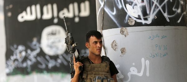 A member of Iraqi counterterrorism forces stands guard near Islamic State group militant graffiti in Fallujah, Iraq (File) - Sputnik Afrique