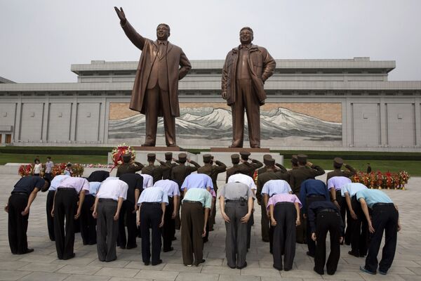 Vénération des statues en bronze des anciens dirigeants nord-coréens Kim Il-sung et Kim Jong -il à l’occasion de l’anniversaire de la fin de la colonisation japonaise - Sputnik Afrique
