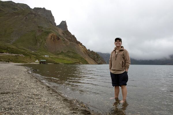 Австралийская туристка стоит в озере Чхонджи во время остановки по пути к священной горе Пэктусан в КНДР - Sputnik Afrique