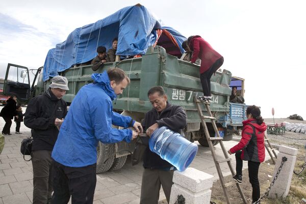 Пополнение запасов воды иностранными туристами по пути к горе Пэктусан в КНДР - Sputnik Afrique
