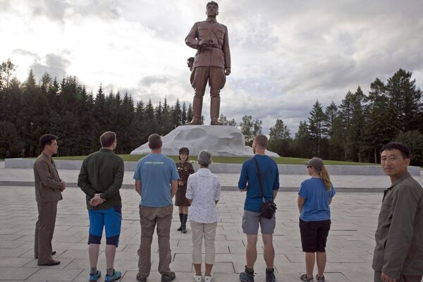Группа иностранных туристов во время посещения памятника близ коры Пэктусан в КНДР - Sputnik Afrique