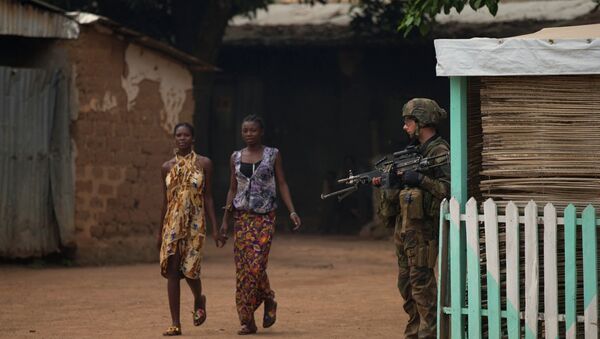 Girls hold hands as they walk past a French soldier holding a position, during an operation to secure part of the Miskine neighborhood, in Bangui, Central African Republic, Thursday, Dec. 26, 2013 - Sputnik Afrique