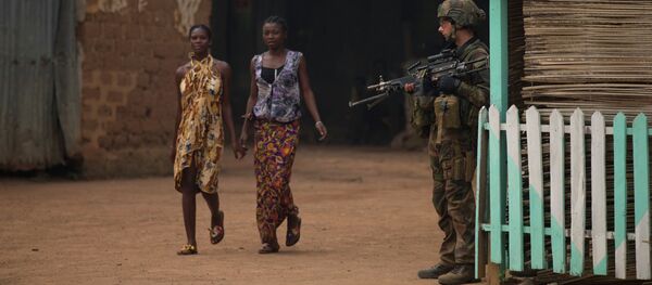 Girls hold hands as they walk past a French soldier holding a position, during an operation to secure part of the Miskine neighborhood, in Bangui, Central African Republic, Thursday, Dec. 26, 2013 - Sputnik Afrique