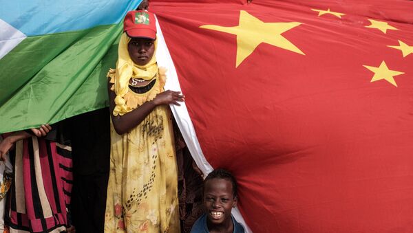 People hold Chinese and Djiboutian national flags as they wait for the arrival of Djibouti's President Ismail Omar Guellehas before the launching ceremony of new 1000-unit housing contruction project in Djibouti, on July 4, 2018. - Sputnik Afrique