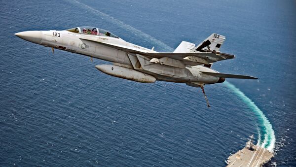 An F/A-18F Super Hornet jet flies over the USS Gerald R. Ford as the U.S. Navy aircraft carrier tests its EMALS magnetic launching system, which replaces the steam catapult, and new AAG arrested landing system in the Atlantic Ocean - Sputnik Afrique