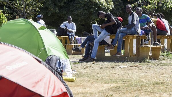 Migrants and refugees sit at Daviais square in Nantes, western France, after being evacuated from a deserted school by the police, on August 2, 2018. - Sputnik Afrique
