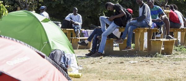 Migrants and refugees sit at Daviais square in Nantes, western France, after being evacuated from a deserted school by the police, on August 2, 2018. - Sputnik Afrique