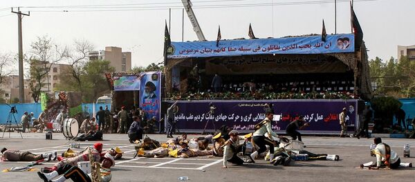This picture taken on September 22, 2018 in the southwestern Iranian city of Ahvaz shows injured soldiers lying on the ground at the scene of an attack on a military parade that was marking the anniversary of the outbreak of its devastating 1980-1988 war with Saddam Hussein's Iraq. - Sputnik Afrique