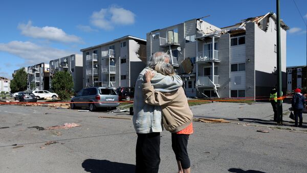 Residents embrace while looking at damage after a tornado hit the Mont-Bleu neighbourhood in Gatineau, Quebec, Canada, September 22, 2018. - Sputnik Afrique