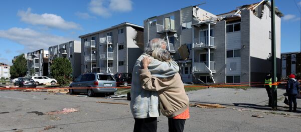 Residents embrace while looking at damage after a tornado hit the Mont-Bleu neighbourhood in Gatineau, Quebec, Canada, September 22, 2018. - Sputnik Afrique