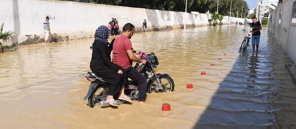 A motorcyclist rides in the flooded water in the Tunisian coastal governorate of Nabeul on September 23, 2018 following deadly flash flooding in the town of Bir Challouf. - Sputnik Afrique