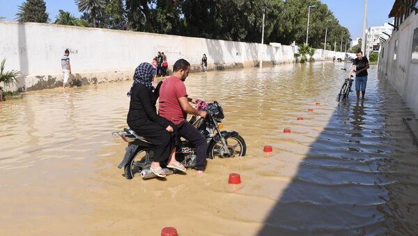 A motorcyclist rides in the flooded water in the Tunisian coastal governorate of Nabeul on September 23, 2018 following deadly flash flooding in the town of Bir Challouf. - Sputnik Afrique