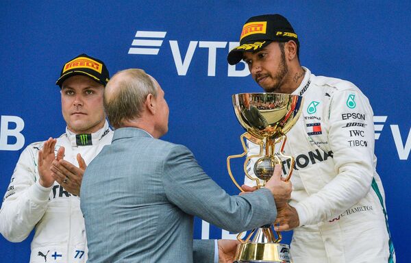 Lewis Hamilton reçoit le trophée des mains de Vladimir Poutine Lewis Hamilton reçoit le trophée des mains de Vladimir Poutine - Sputnik Afrique