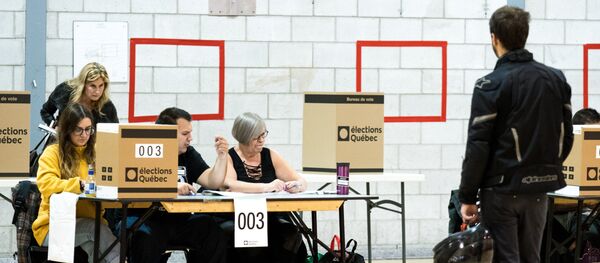 A man casts his ballot at a polling station in the provincial elections on October 1, 2018 in Montreal, Quebec. - Sputnik Afrique