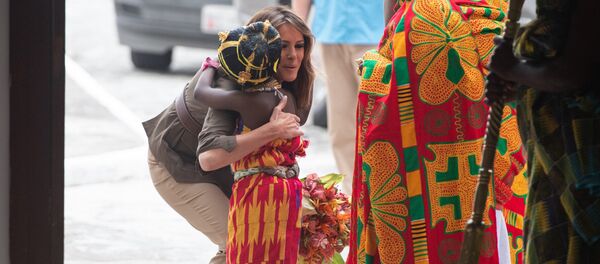 US First Lady Melania Trump hugs a young girl as she arrives at the Emintsimadze Palace in Cape Coast, Ghana, on October 3, 2018. - Sputnik Afrique