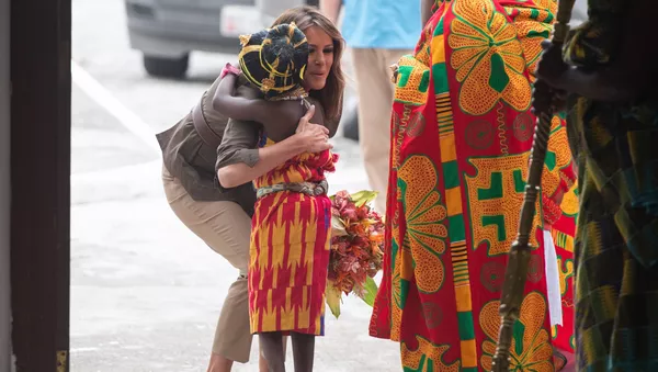 US First Lady Melania Trump hugs a young girl as she arrives at the Emintsimadze Palace in Cape Coast, Ghana, on October 3, 2018. - Sputnik Afrique
