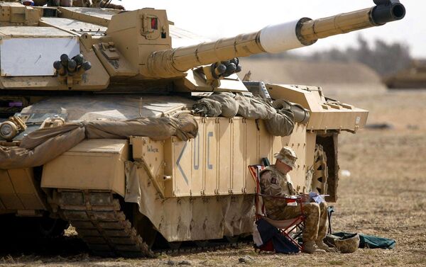 A soldier of the Scots Dragoon Guards sits by a Challenger 2 tank, right, as another sits on top, after being involved in action in Basra, southern Iraq, Saturday 29, 2003 - Sputnik Afrique