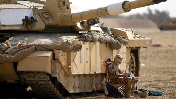 A soldier of the Scots Dragoon Guards sits by a Challenger 2 tank, right, as another sits on top, after being involved in action in Basra, southern Iraq, Saturday 29, 2003 - Sputnik Afrique