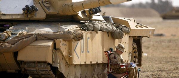 A soldier of the Scots Dragoon Guards sits by a Challenger 2 tank, right, as another sits on top, after being involved in action in Basra, southern Iraq, Saturday 29, 2003 - Sputnik Afrique