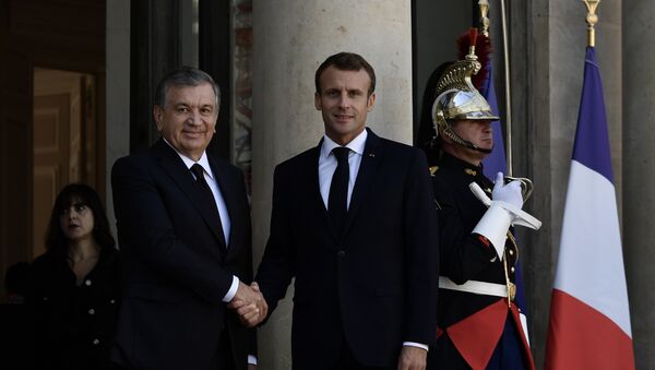 French President Emmanuel Macron (R) shakes hands with the President of Uzbekistan Shavkat Mirziyoyev at the Elysee Palace in Paris on October 9, 2018. - Sputnik Afrique