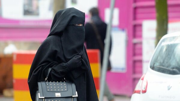 A woman wearing a niqab, a type of full veil, as she walks in a street in the center of Roubaix, northern France, on January 9, 2014. - Sputnik Afrique