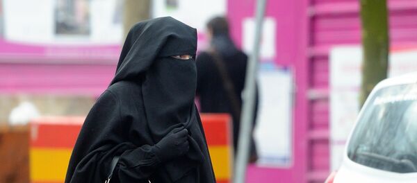 A woman wearing a niqab, a type of full veil, as she walks in a street in the center of Roubaix, northern France, on January 9, 2014. - Sputnik Afrique