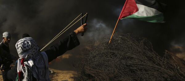 A female protester hurls a stone while others burn tires near the fence of the Gaza Strip border with Israel, during a protest east of Khan Younis, southern Gaza Strip, Friday, Aug. 10, 2018. Violence erupted at the Gaza border Friday after the territory's militant Islamic Hamas rulers and Israel appeared to be honoring a cease-fire that ended two days of intense violence amid efforts by neighboring Egypt to negotiate between the two sides - Sputnik Afrique