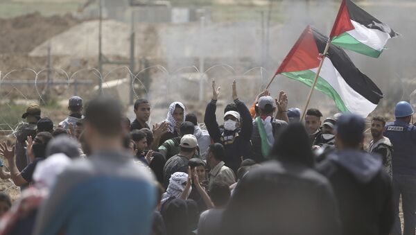 Palestinian protesters chant slogans as they gather during a protest at the Gaza Strip's border with Israel, Friday, April 13, 2018 - Sputnik Afrique