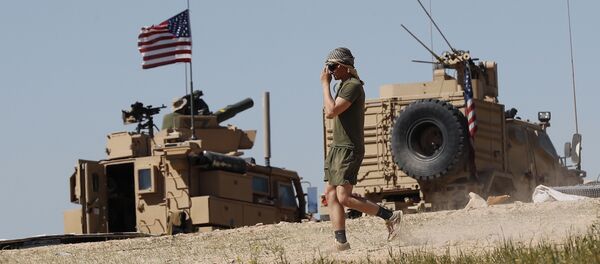 A U.S. soldier walks on a newly installed position, near the tense front line between the U.S-backed Syrian Manbij Military Council and the Turkish-backed fighters, in Manbij, north Syria, Wednesday, April 4, 2018. - Sputnik Afrique