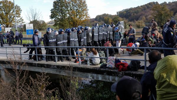 Croatian riot police stand guard in front of migrants at Maljevac border crossing between Bosnia and Croatia near Velika Kladusa, Bosnia, October 24, 2018. - Sputnik Afrique